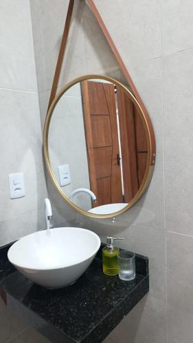 a bathroom with a white sink and a mirror at Lar doce lar in Paragominas