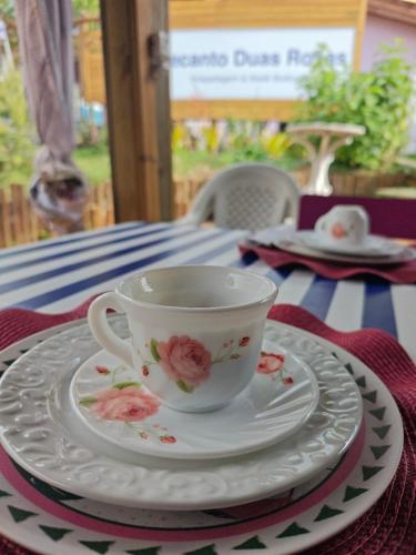 a coffee cup and saucer sitting on a table at Recanto Duas Rosas in Venda Nova do Imigrante