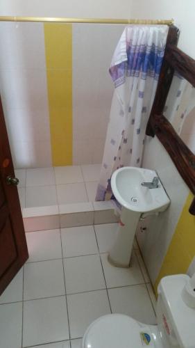 a bathroom with a toilet and a sink at Charo´s Hostal in Montañita