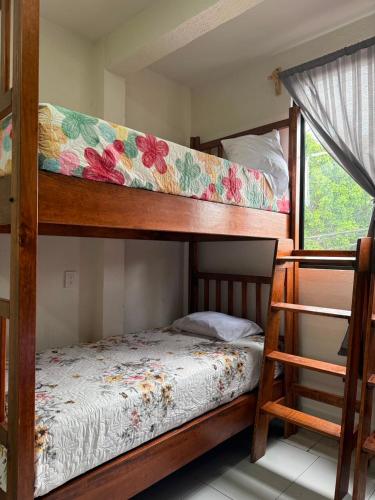 a bedroom with two bunk beds and a window at Casa Flor in San Antonio de la Cal