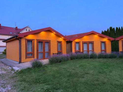 an orange house with a lawn in front of it at Willa Aleksander in Rewal