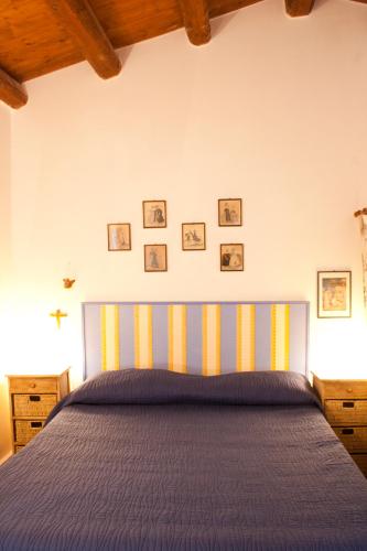 a bedroom with a blue bed with pictures on the wall at Agosud Casa vacanze in Marzamemi
