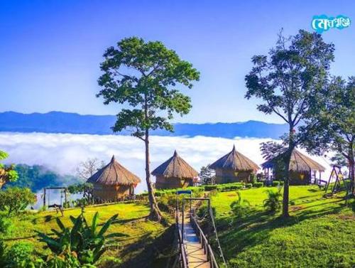 a group of huts in a field with trees at SA Housing 2 in Rangpur