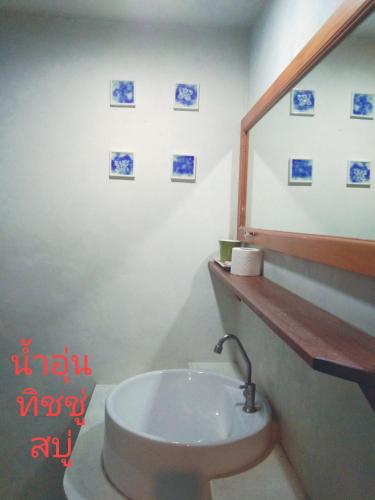 a bathroom with a white sink and a mirror at THAMONWAN hostel in Cha Am