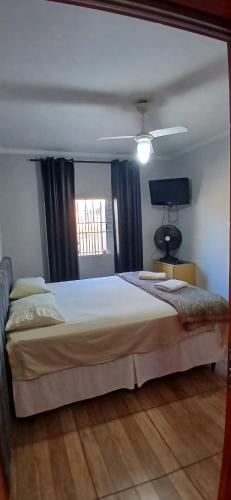 a bedroom with a large bed and a window at Quarto Casal Cinza in Artur Nogueira