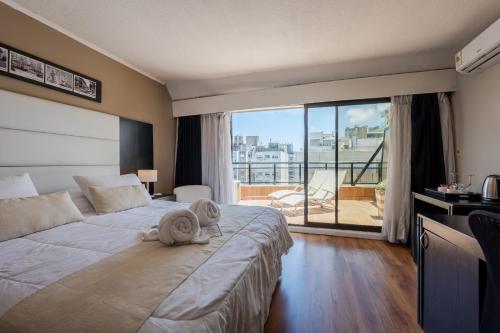 a bedroom with a large bed with towels on it at Pocitos Plaza Hotel in Montevideo