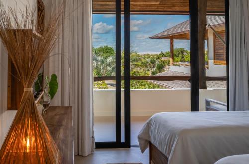 a bedroom with a bed and a view of the ocean at Villa Florens in Jericoacoara