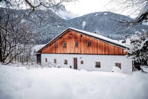 a barn in the snow with snow covered trees at Wassermann in Sesto