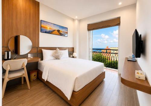 a bedroom with a bed and a balcony with a television at Anna seaview hotel in Phú Quốc
