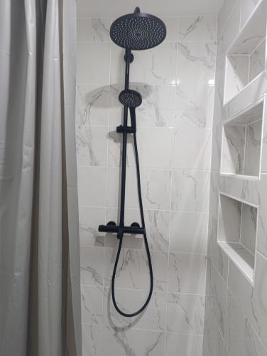 a shower with a black shower head in a bathroom at Studio cosy Boulazac in Boulazac