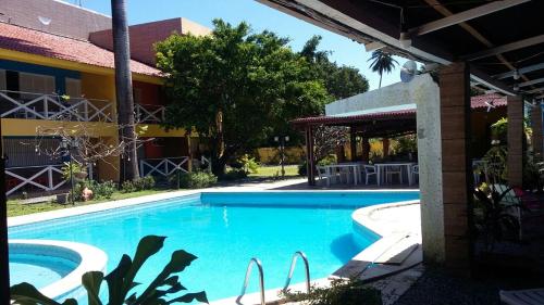 a swimming pool in front of a building at Pousada Recanto do Sossego in Itamaracá
