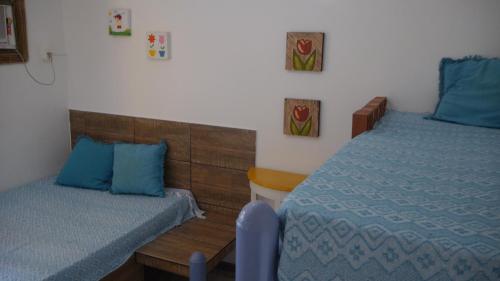 a bedroom with two beds with blue pillows at Pousada Recanto do Sossego in Itamaracá