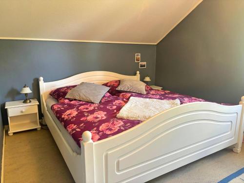 a bedroom with a white bed with purple sheets and pillows at Hus Fee in Fredriksberg