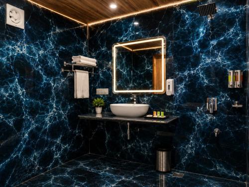a blue marble bathroom with a sink and mirror at Desert Popular Resort & Camp in Jaisalmer