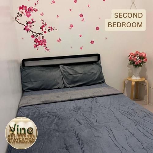 a bedroom with a bed with pink flowers on the wall at Vine Residences Staycation in Manila
