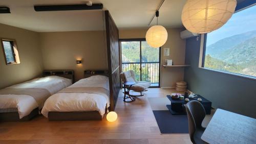 a bedroom with two beds and a view of a mountain at Tiny House Iyashirochi Kaze in Miyoshi