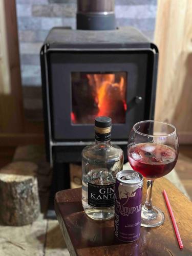 a bottle of gin and a glass of wine on a table at Casa Salto Pichi Ignao in Lago Ranco