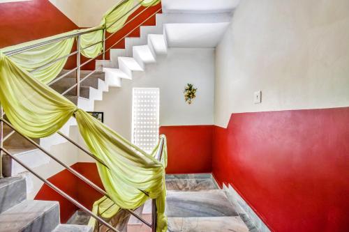 a room with red and white walls and a staircase at OYO 80514 Moody Moon in Bārang