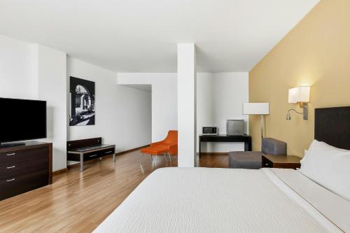 a hotel room with a bed and a flat screen tv at Fiesta Inn Express Perinorte in Mexico City