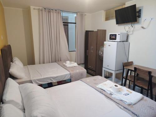 a hospital room with two beds and a television at Hospedaje Kaiak in Pacasmayo
