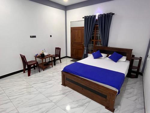 a bedroom with a bed and a table and chairs at RKM Hotel Uppuveli in Trincomalee
