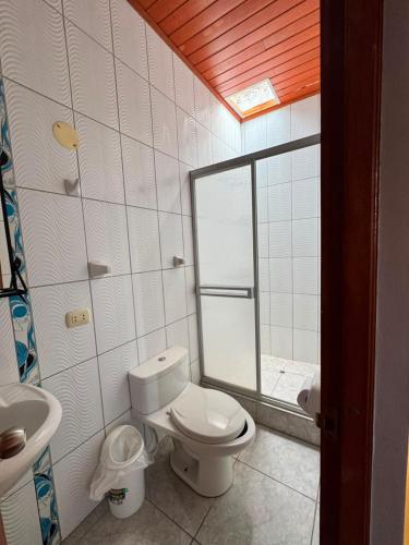 a bathroom with a toilet and a sink and a mirror at Hotel Confort Amazónico in Iquitos