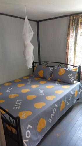 a bed with a blue comforter with yellow polka dots at Knox's Beachfront Homestay in Nalauwaki
