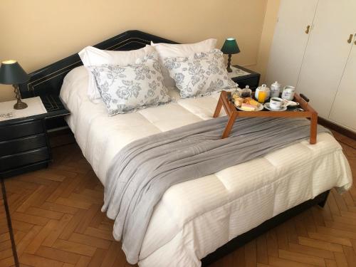 a bed with a tray of food on top of it at Casa Hanami, habitación doble excelente ubicación in Salta