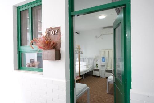 an open door to a room with a bedroom at Peking Station Hostel in Beijing