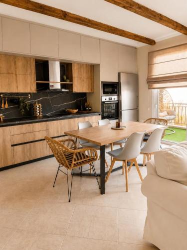 a kitchen with a wooden table and chairs at Terra boho apartment in Ambelákia