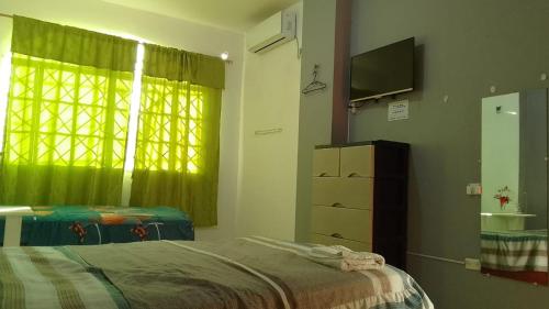 a bedroom with a bed and a television and a window at Hostal La GRAN Familia in Manta