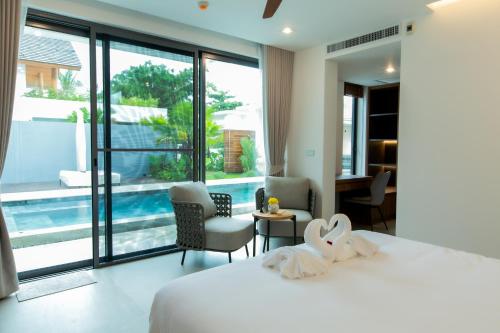 a bedroom with a bed and a view of a pool at Masima Samui Villa in Koh Samui