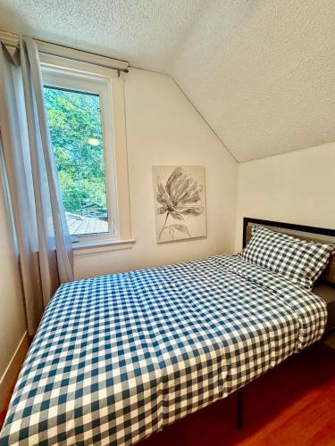 a bedroom with a checkered bed and a window at Cozy Full House 3 bedrooms in Regina