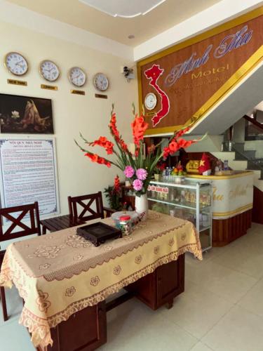 a table with a vase of flowers on it at MINH THU MOTEL in Quảng Ngãi