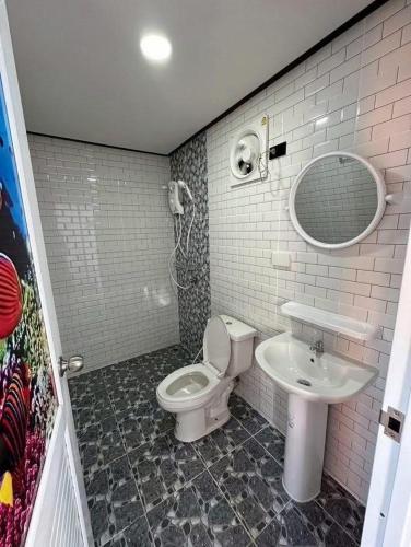 a bathroom with a toilet and a sink at ปลายเขื่อนแคมป์ปิ้ง บ้านแฟมรี่ in Sirindhorn