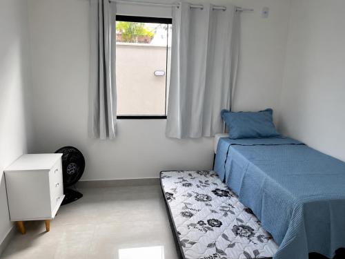 a small bedroom with a bed and a window at Beach Loft - Design e Estilo in Maricá