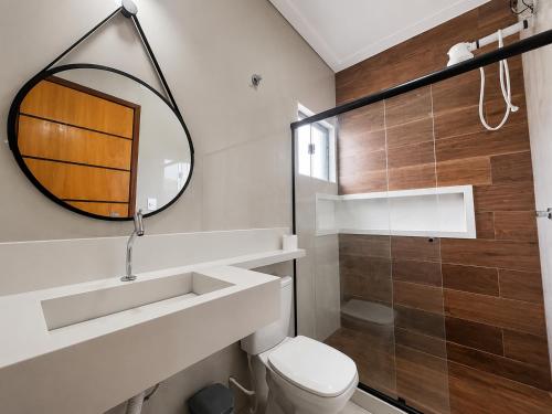 a bathroom with a toilet and a mirror at Beach Loft - Design e Estilo in Maricá