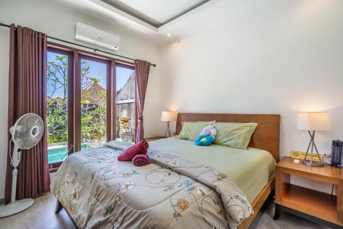 a bedroom with a bed with stuffed animals on it at Casa Dijaweqo in Jimbaran
