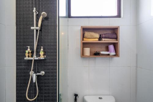 a bathroom with a shower and a toilet at Casa Dijaweqo in Jimbaran