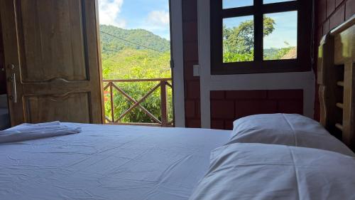 a bedroom with a bed and a window with a view at Mi Ranchito Capurganá in Capurganá
