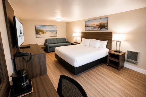 a hotel room with a bed and a chair at Anchor Bay Inn near Winchester Bay in Reedsport