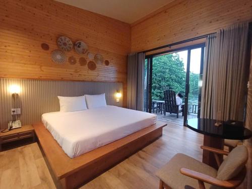a bedroom with a large bed and a large window at Lagoona Eco Resort Binh Chau in Binh Chau