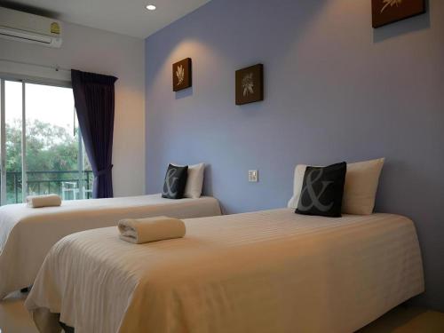 two beds sitting next to each other in a room at Sabai @ Chumphae Hotel in Chum Phae