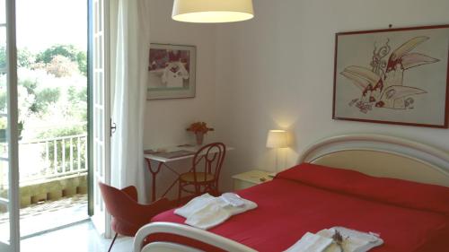 a bedroom with a red bed and a balcony at Giogaia in Modica