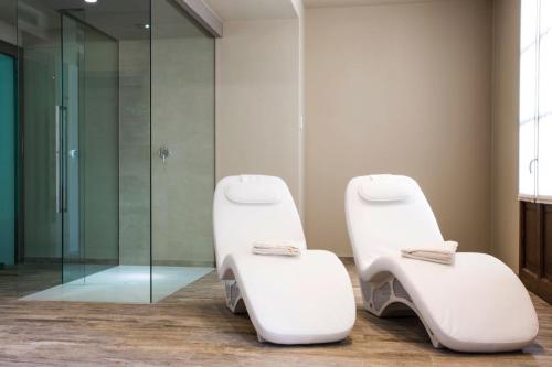 two white chairs in a bathroom with a shower at Il Feudo Di Agnadello in Agnadello