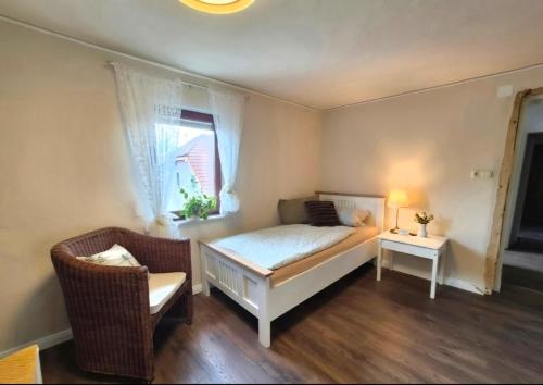 a bedroom with a bed and a chair and a window at Wohnung beim Kodderey ruhig und herzlich in Neuhof