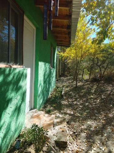 a green and white house with a window at Refugio de Monte in San Luis