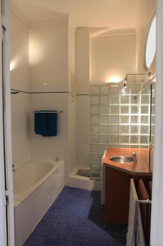 une salle de bain avec un lavabo, une baignoire et une douche dans l'établissement Le Pavillon113, à Cannes