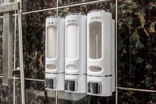 a group of four white toilets on a wall at 구리 호텔 옐로 in Guri