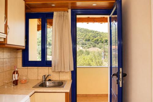 a kitchen with a sink and a window at STUDIOS ATHENA in Megalochori